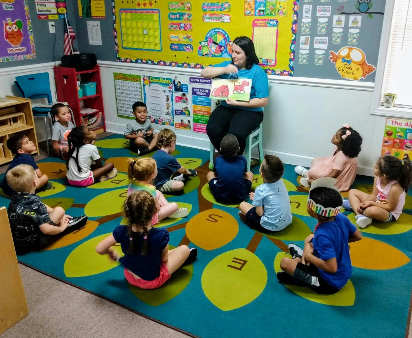 Person reading a book to children in a classroom