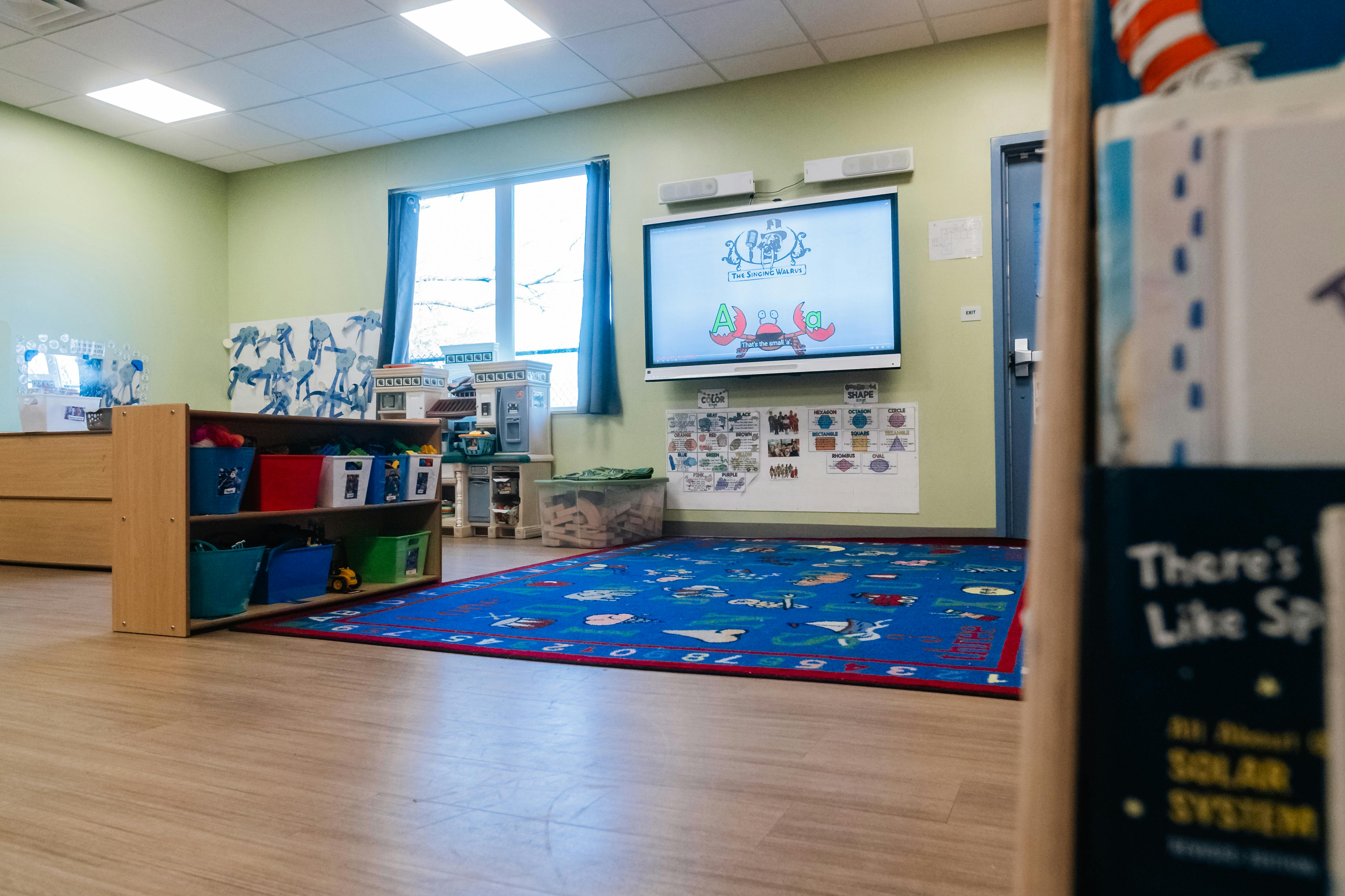Classroom with an interactive screen displaying an alphabet lesson