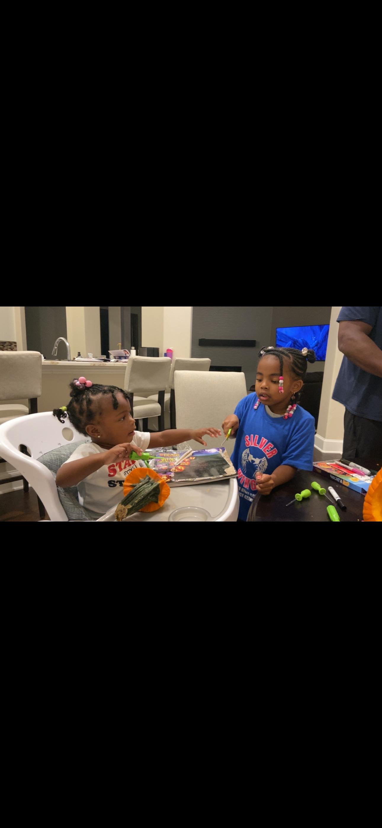 Two children playing with craft supplies at a table