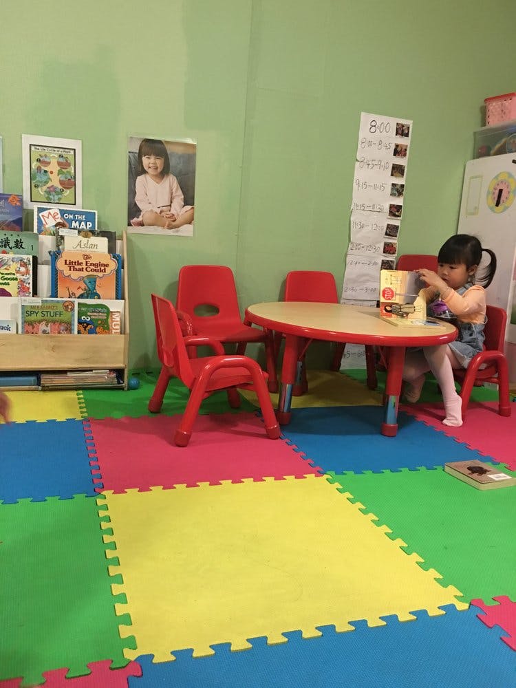 Child sitting at a small table in a classroom