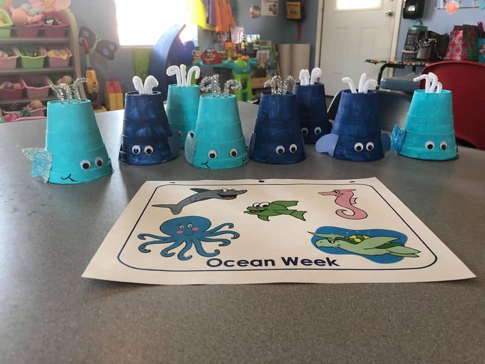 Crafts made from inverted cups with googly eyes and a paper with ocean animals