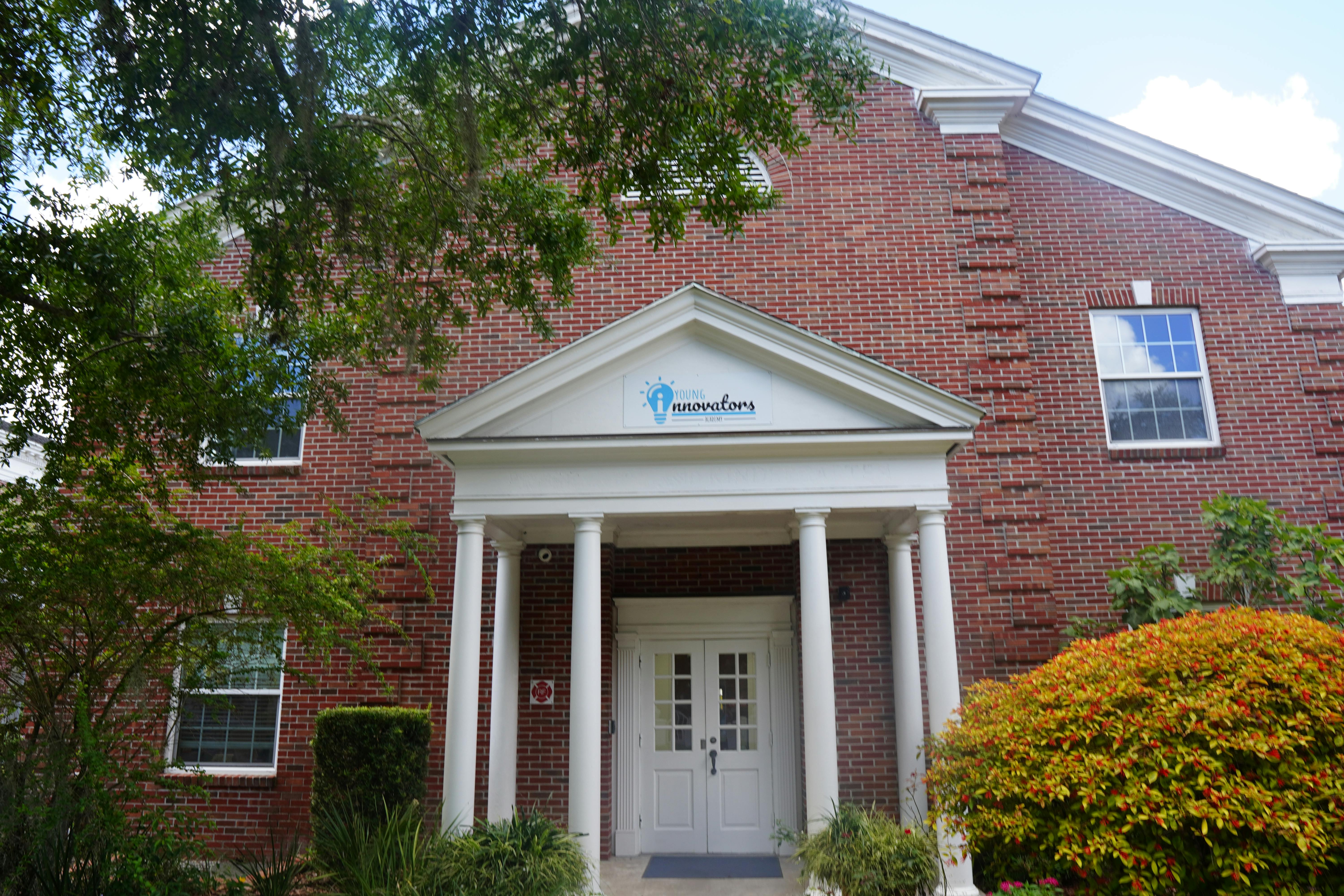Brick building with white columns and a white double door entrance