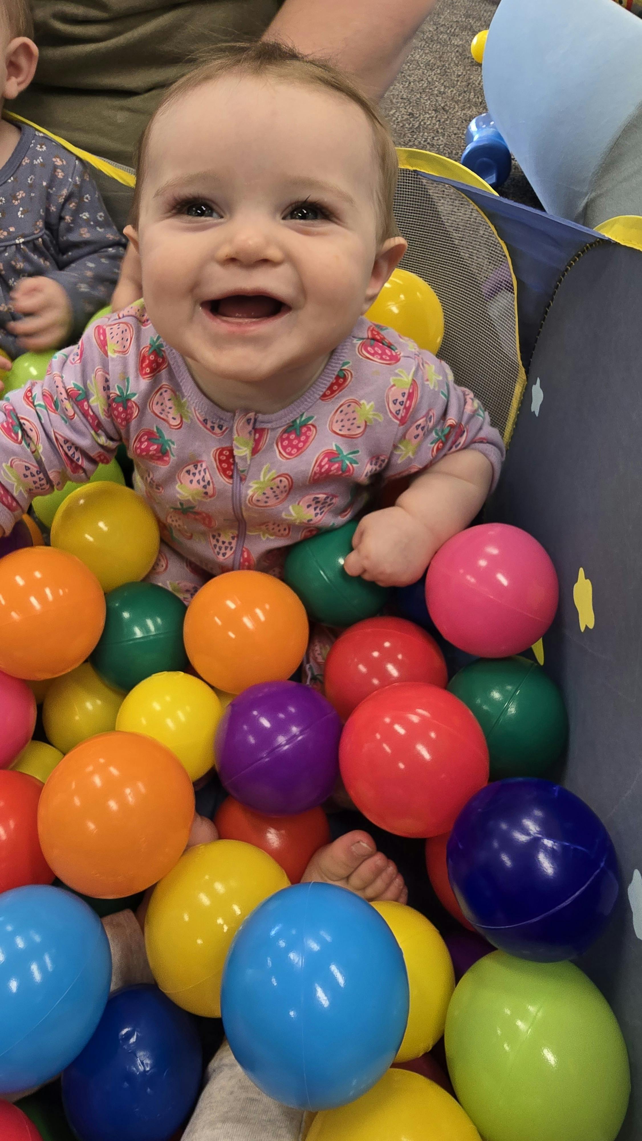Child smiling in a ball pit