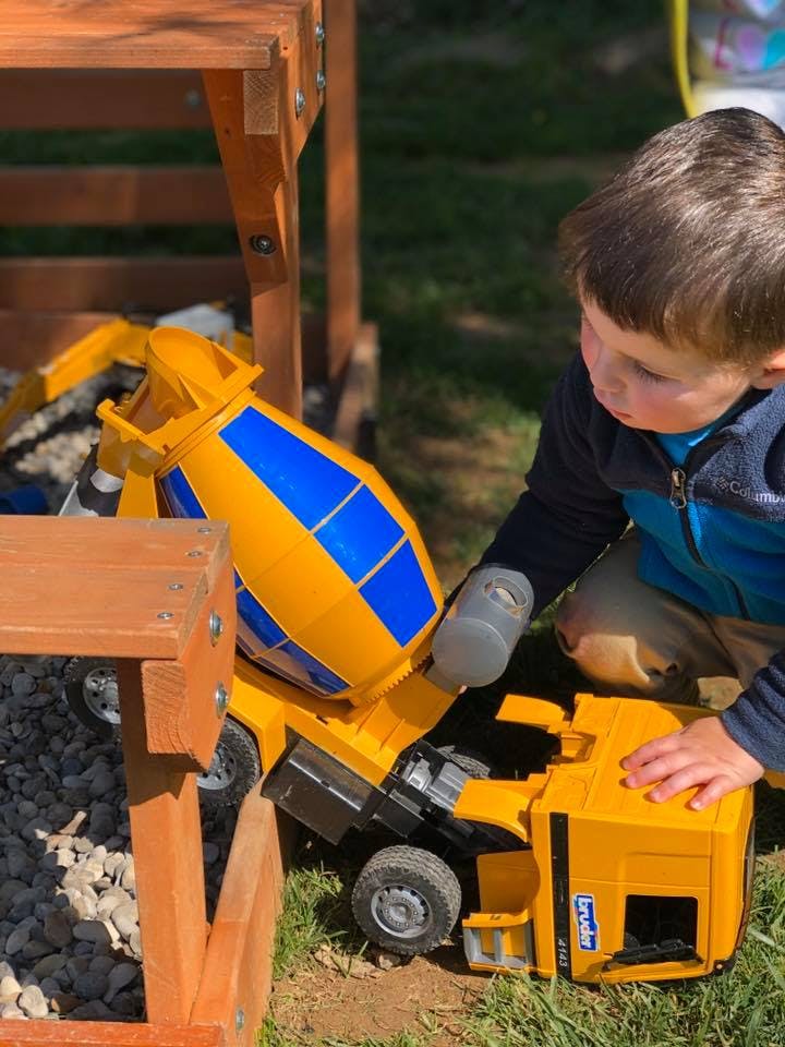Child playing with a toy cement mixer truck