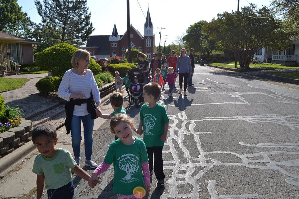 Adults and children walking on a street