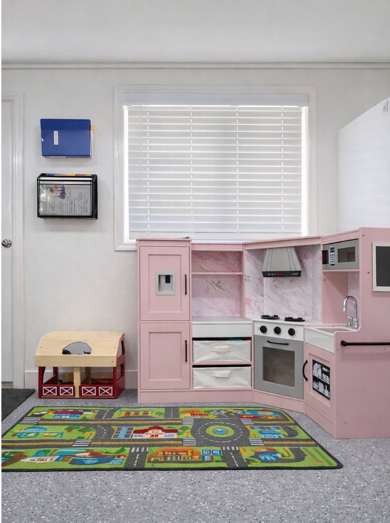 Pink toy kitchen set in a child's play area