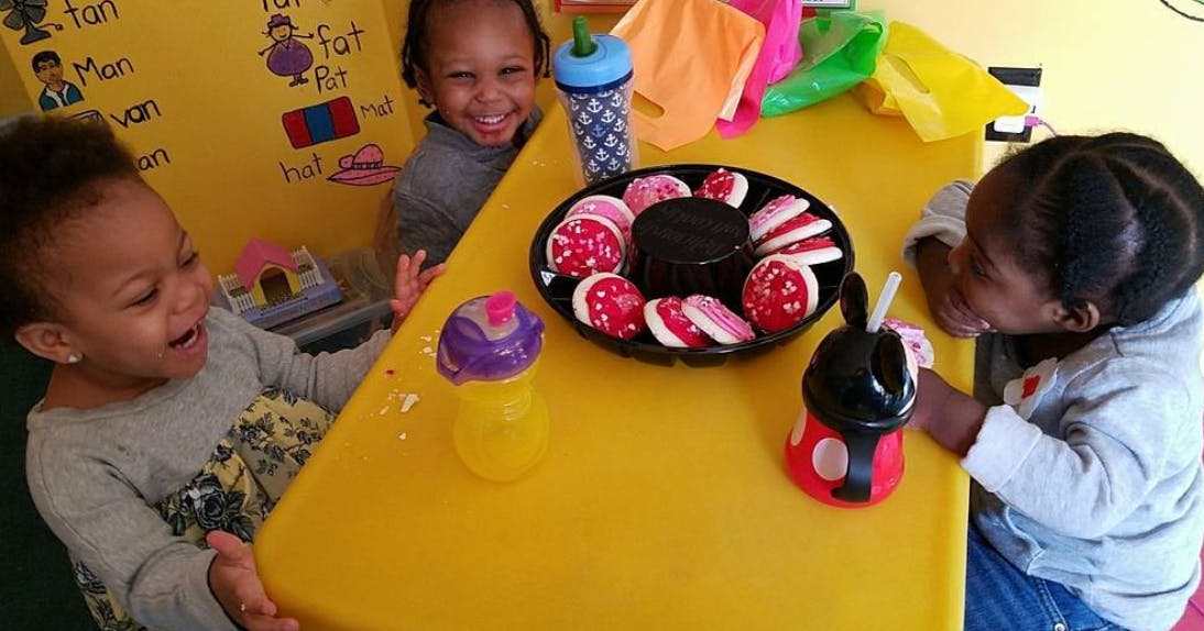 Three children at a table with cookies