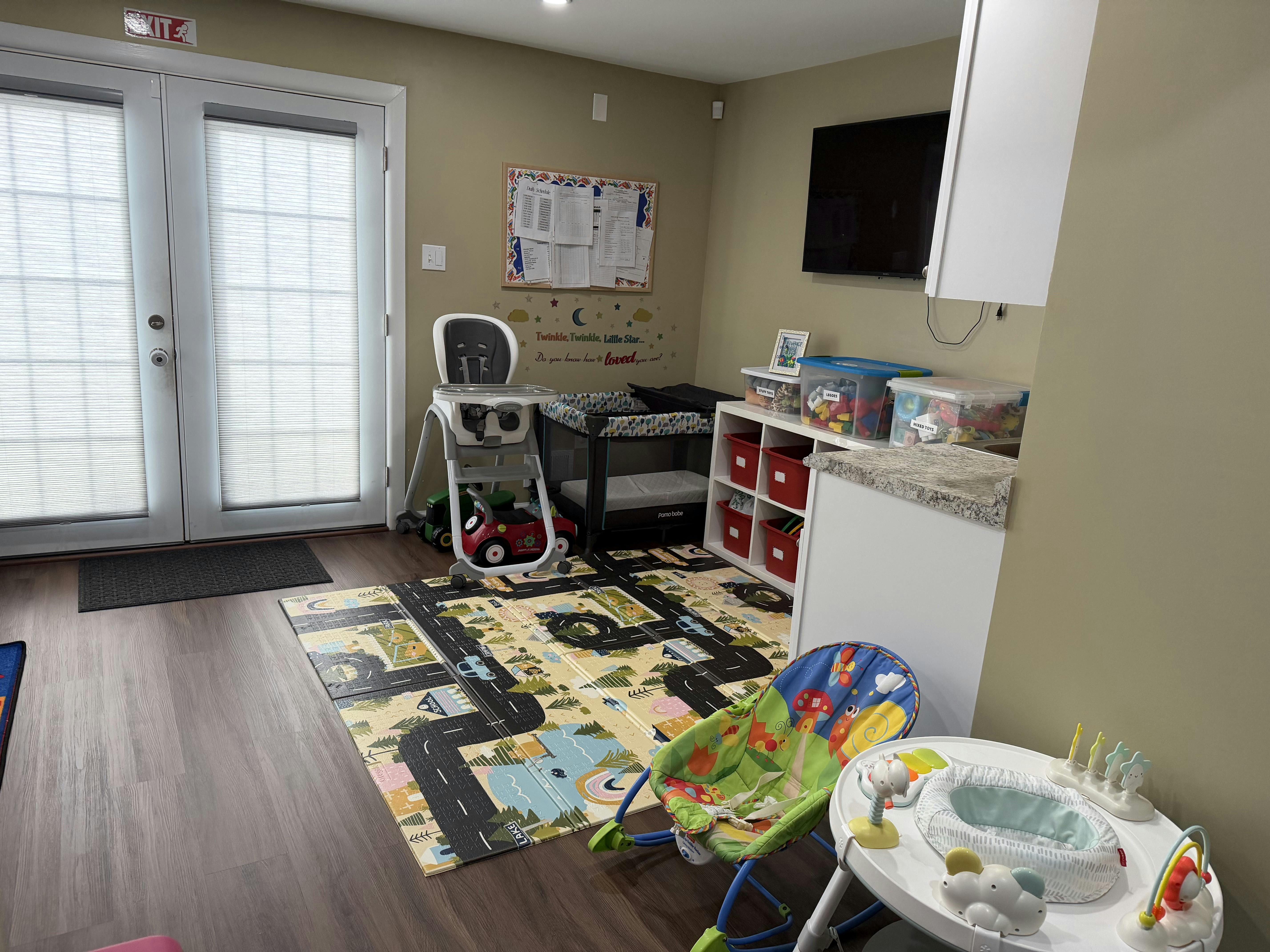 Room with baby play mat, high chair, and changing table