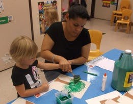 Adult and child doing an art project at a table