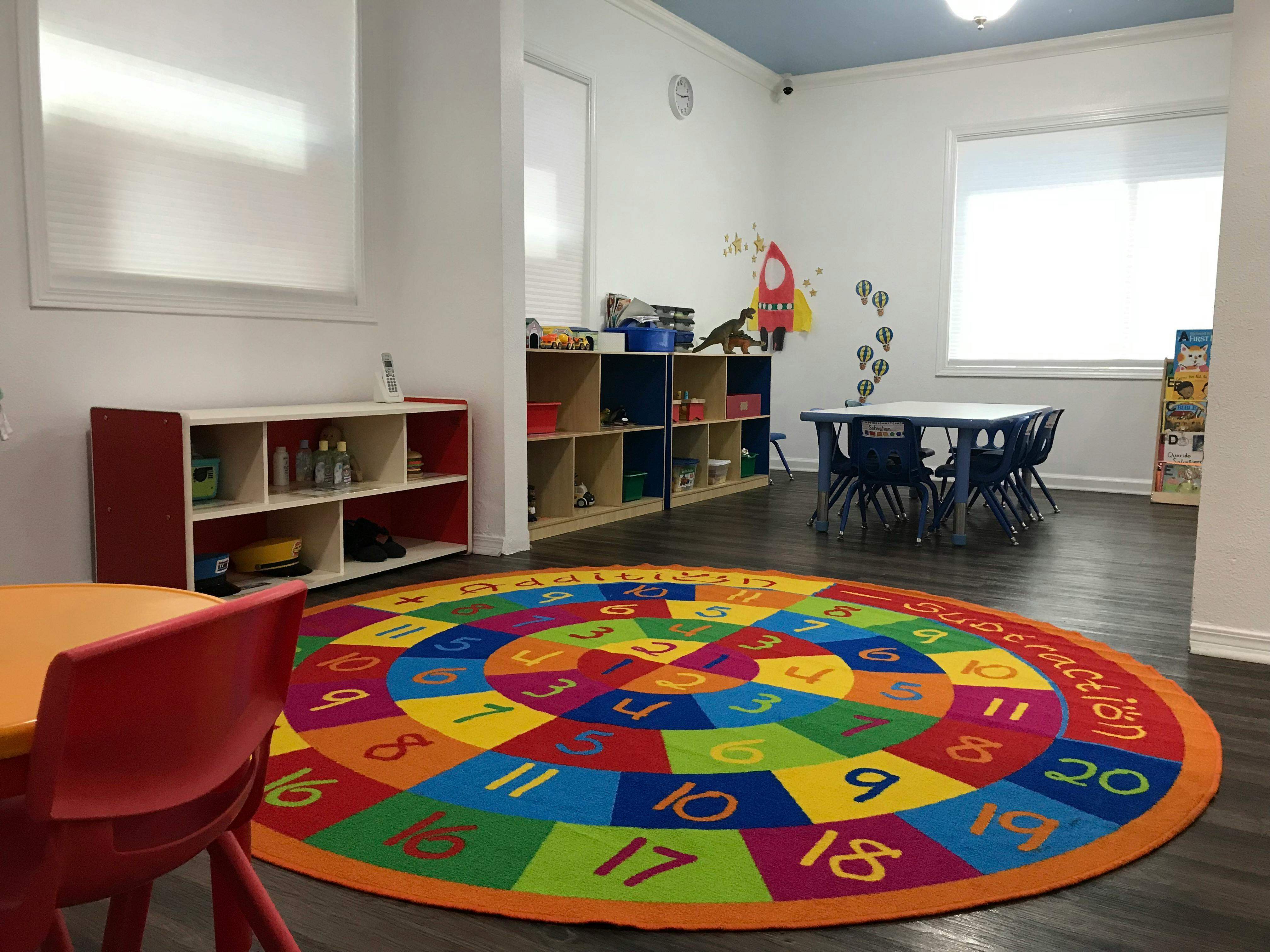 Colorful number rug in a classroom with tables and shelves