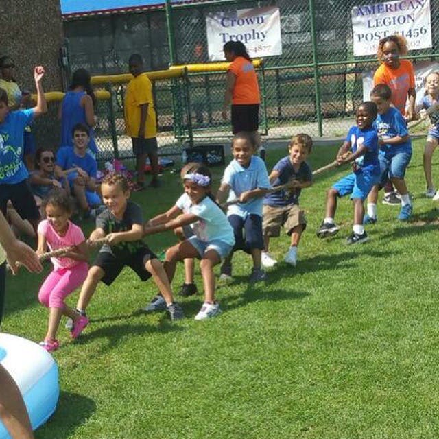 Children playing tug-of-war on grass
