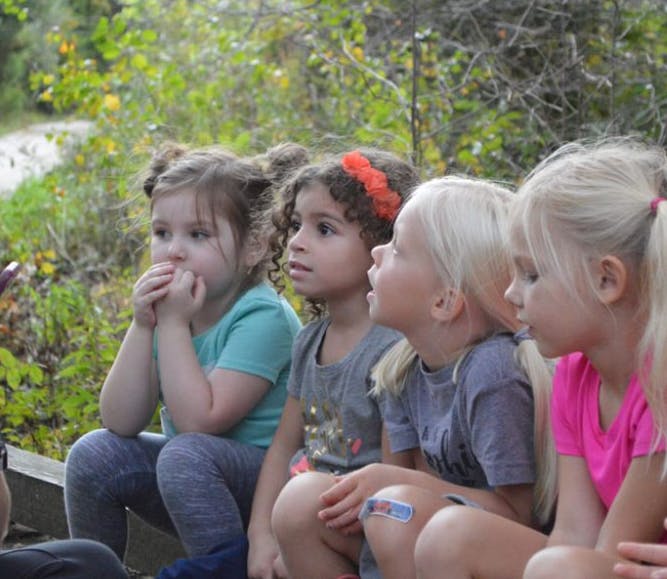Four children sitting and looking in the same direction