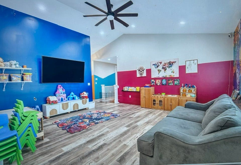 Playroom with blue and pink walls, television, and children's furniture