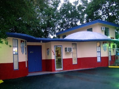 Building with red and yellow walls, blue trim, and a white dome roof