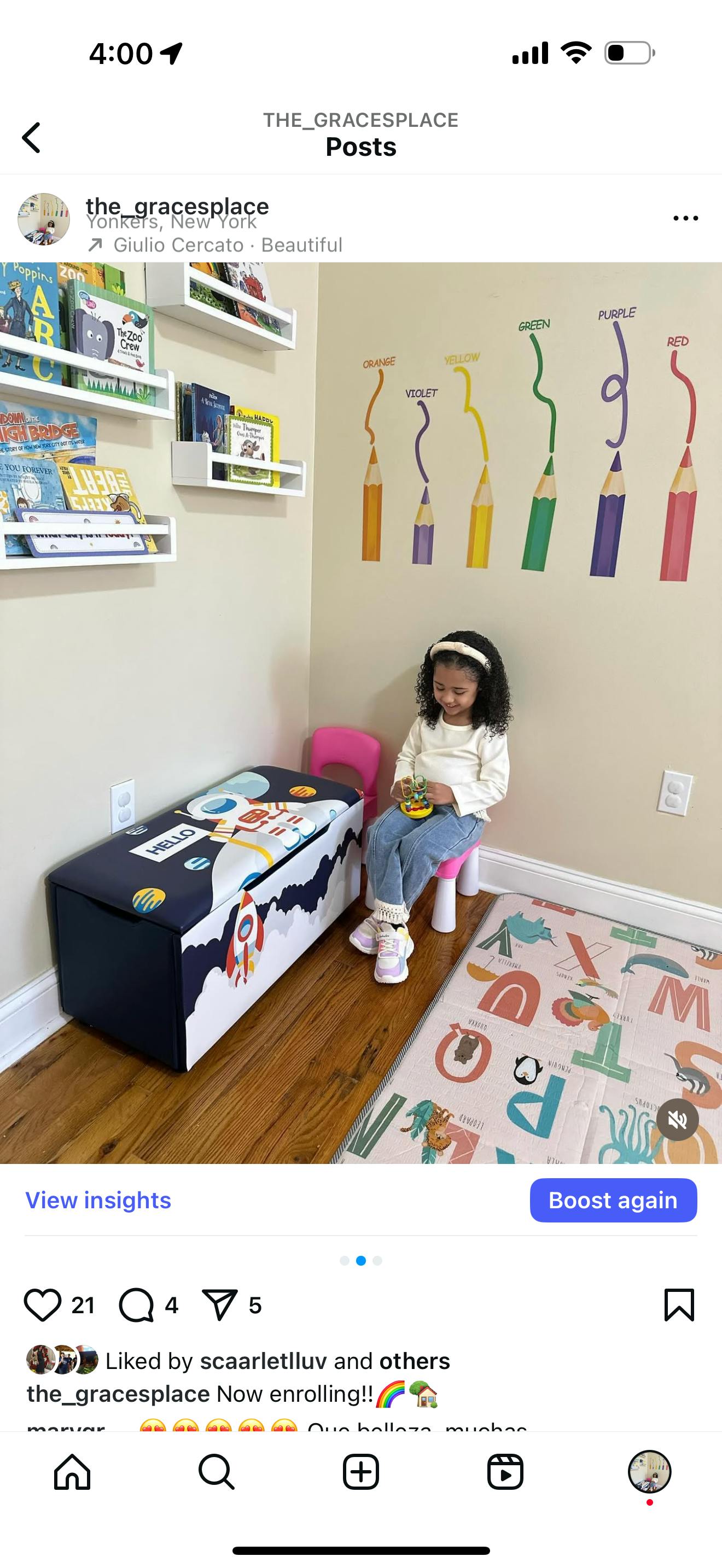 Child sitting on a small stool in a room with books and crayon wall decals