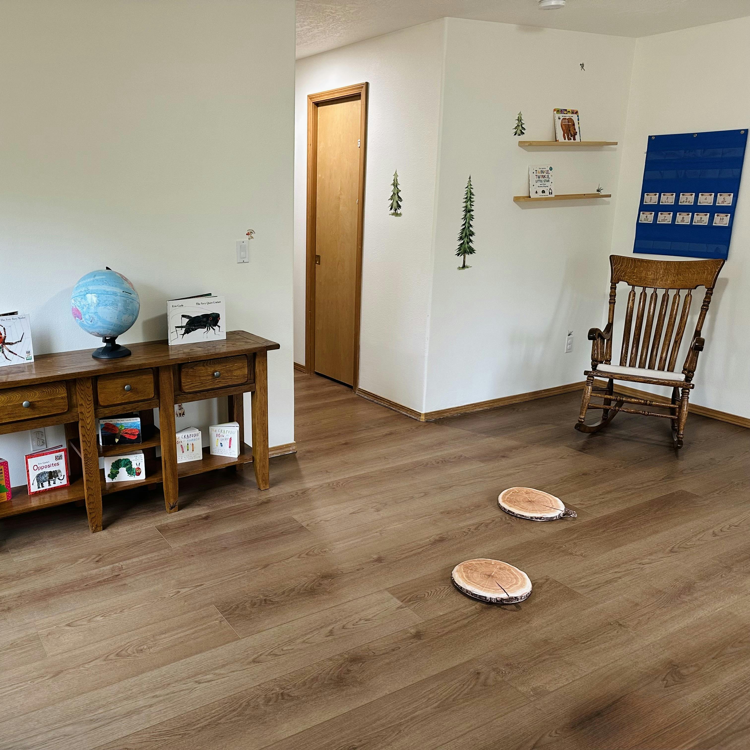 Children's room with wooden furniture, globe, books, and wall decals