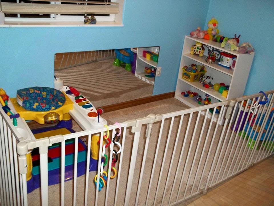 Playpen with toys and a shelf of toys