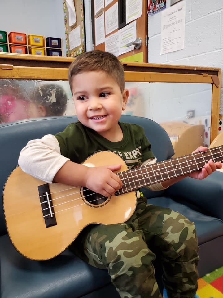 Child playing a ukulele
