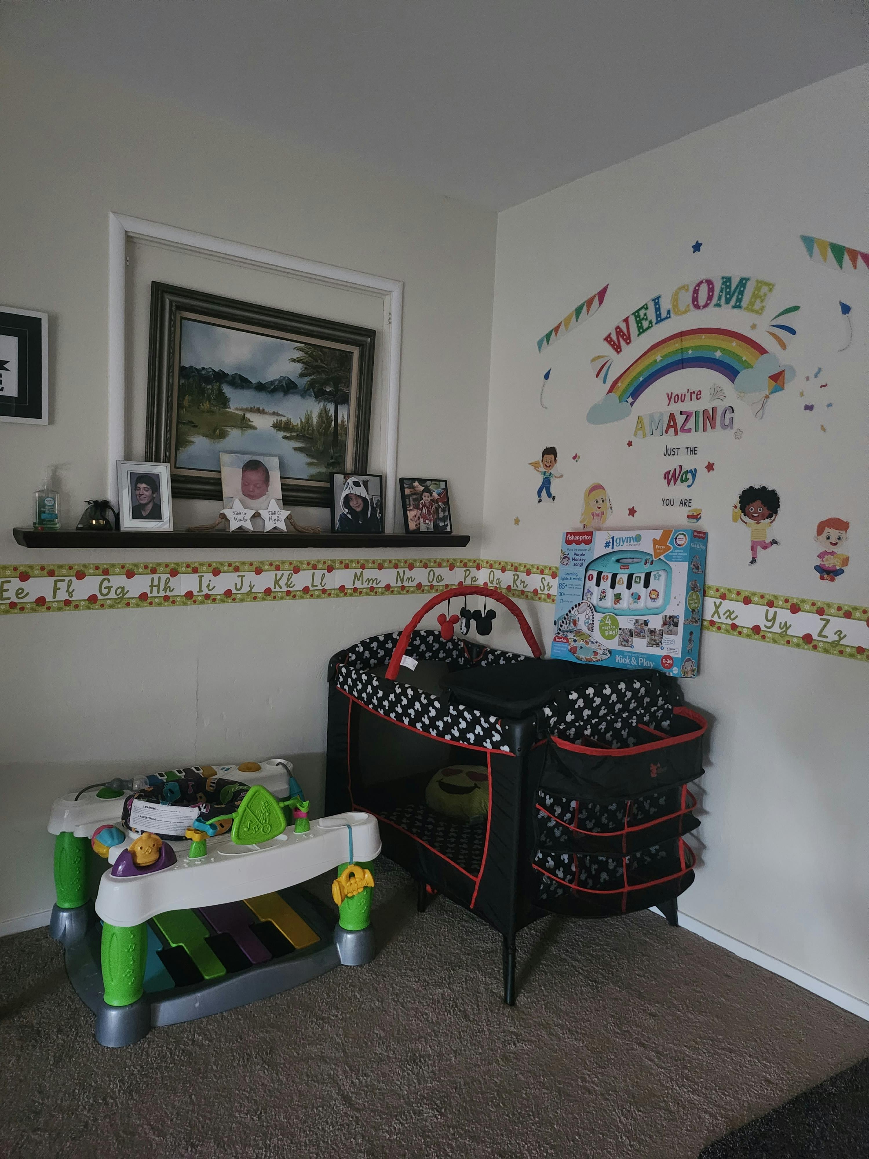Baby playard and activity table in a room with wall decorations