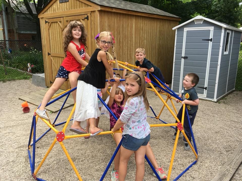 Children climbing on a geometric dome climber