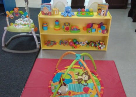 Baby bouncer, play mat, and shelves with toys