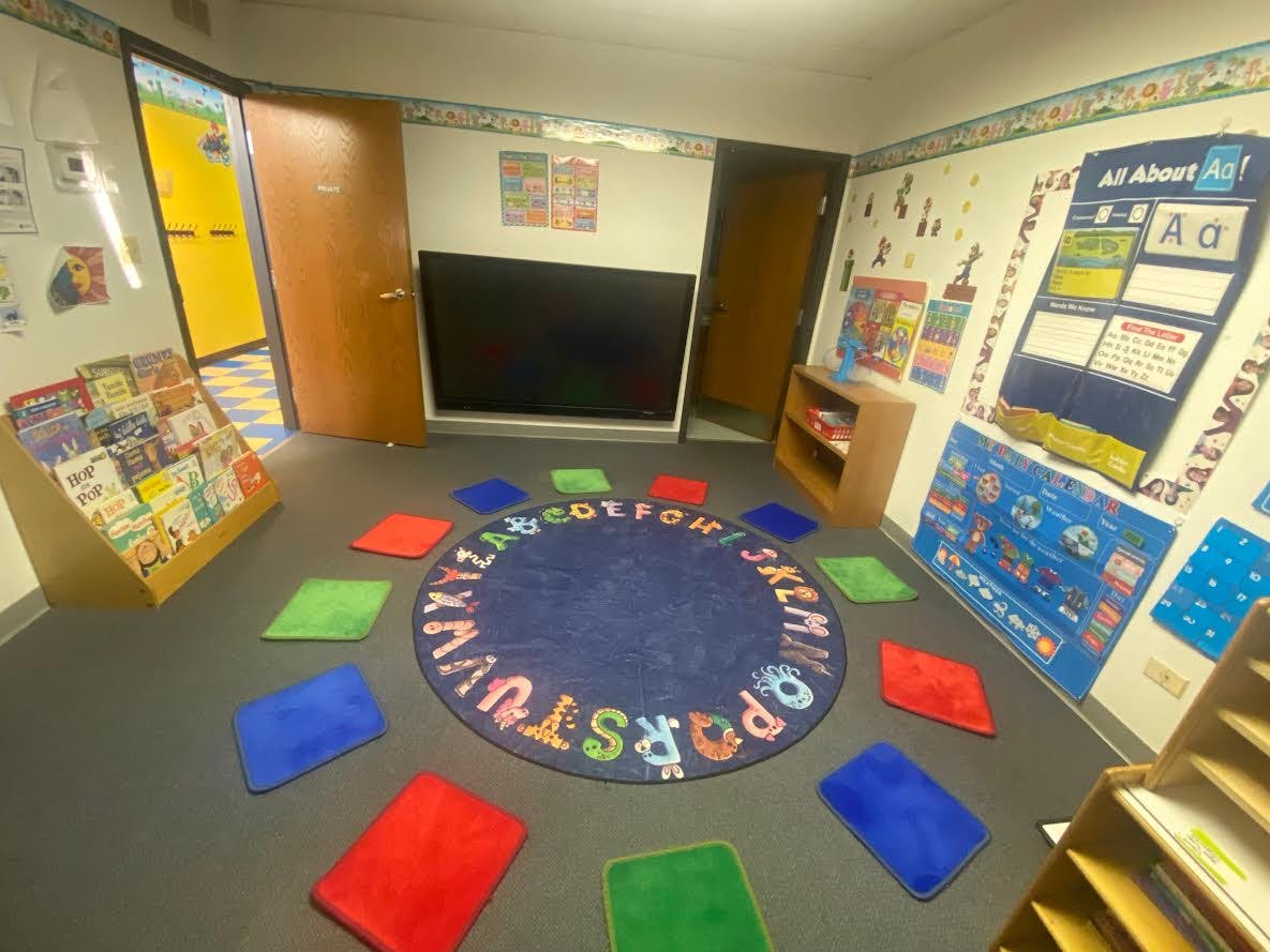 Classroom with alphabet rug and colorful floor cushions