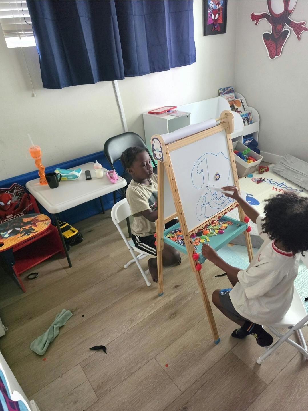 Two children drawing on an easel