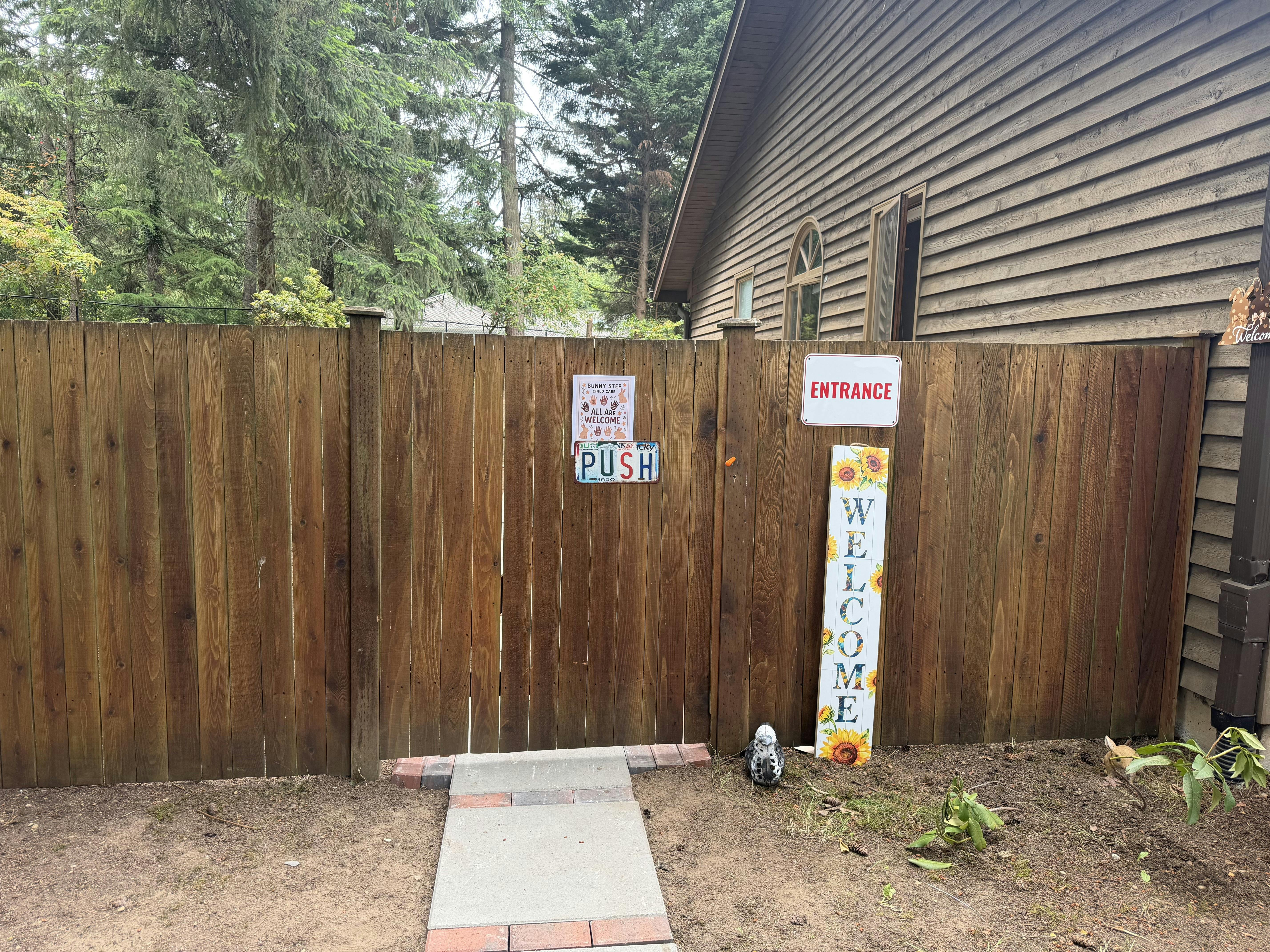 Wooden gate with an Entrance sign and welcome decor