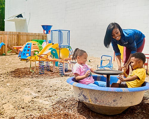 Adult and two children playing on a playground