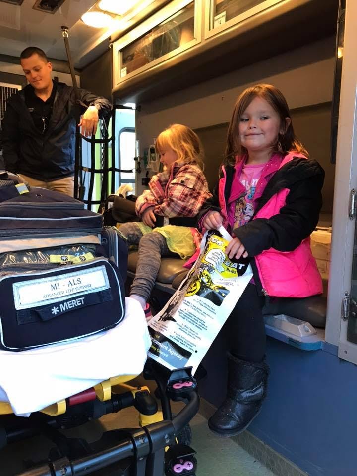 Adult and two children inside an ambulance