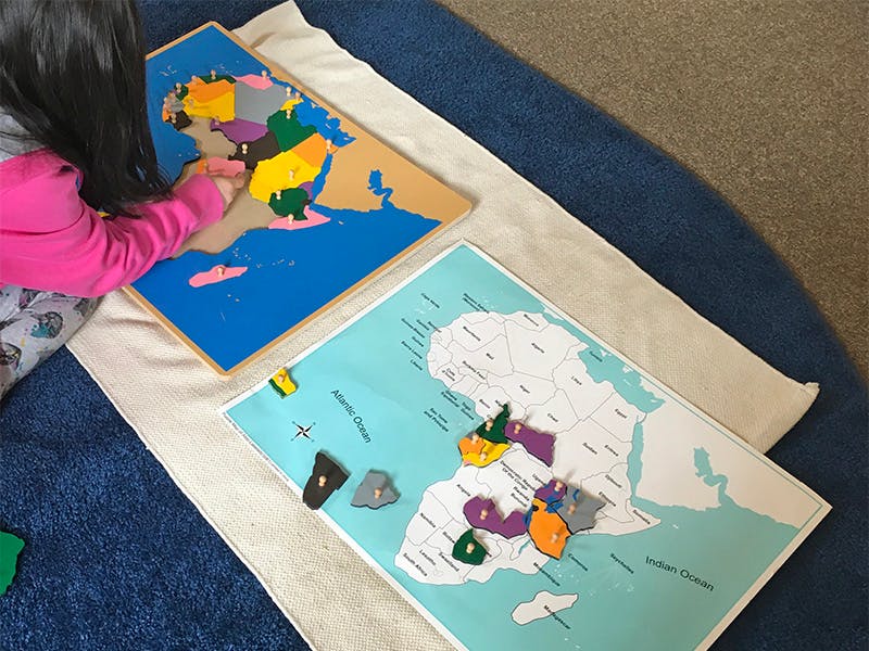 Child playing with a world map puzzle