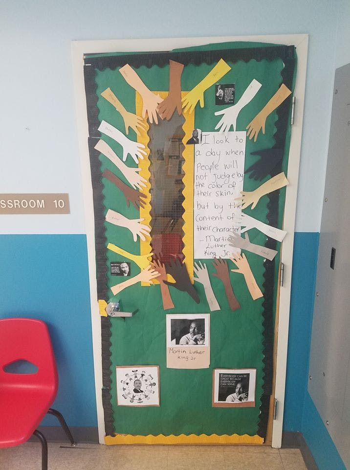 Classroom door decorated with paper cutouts of hands in various skin tones