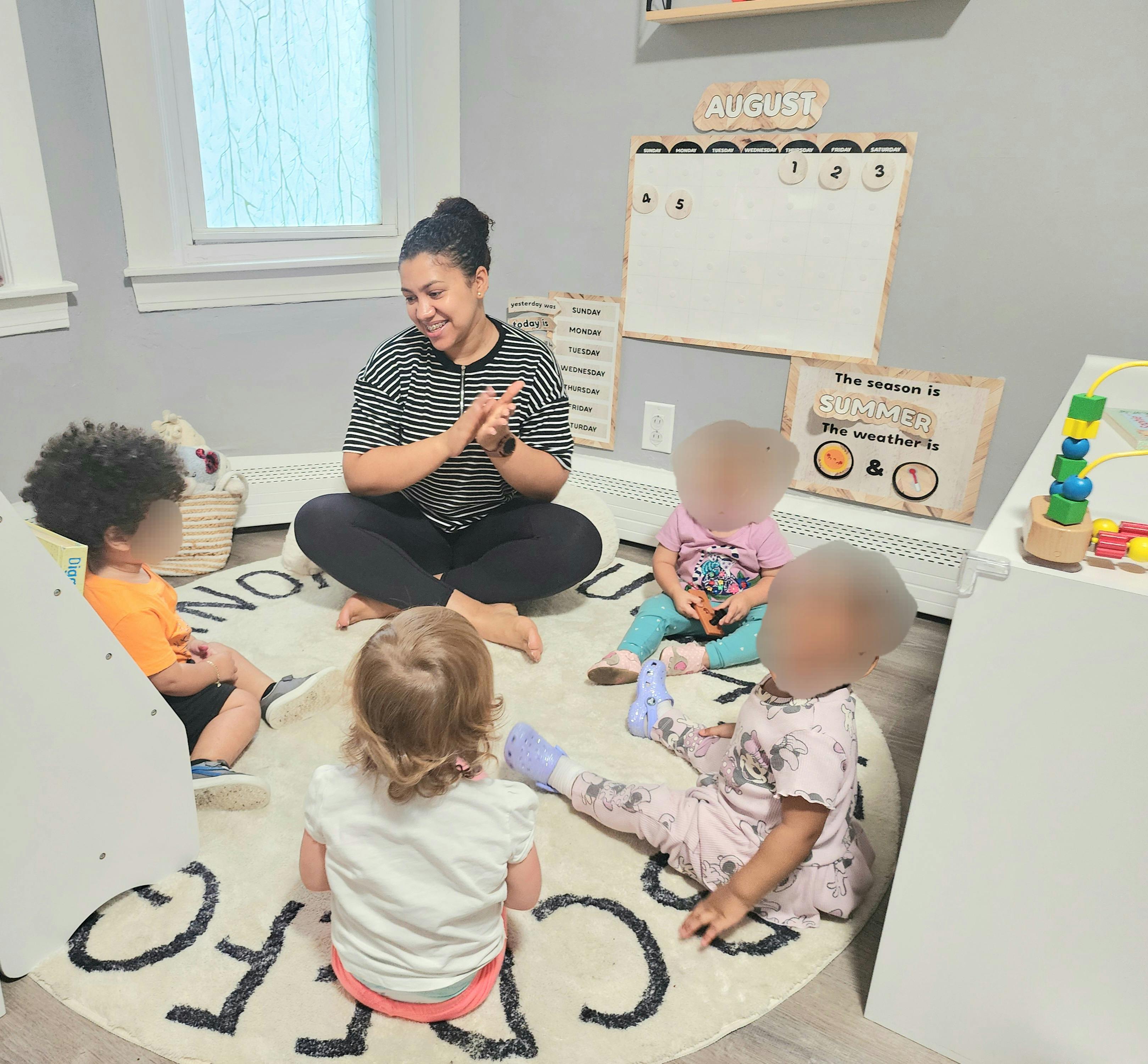 Person sitting on floor with children in a circle
