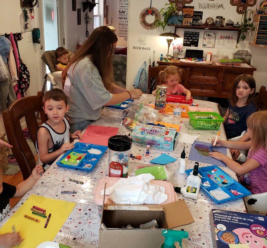 Adult and children doing crafts at a table