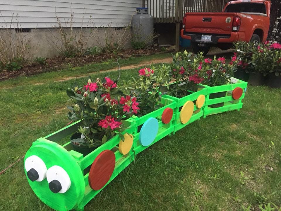 Caterpillar-shaped planter with pink flowers