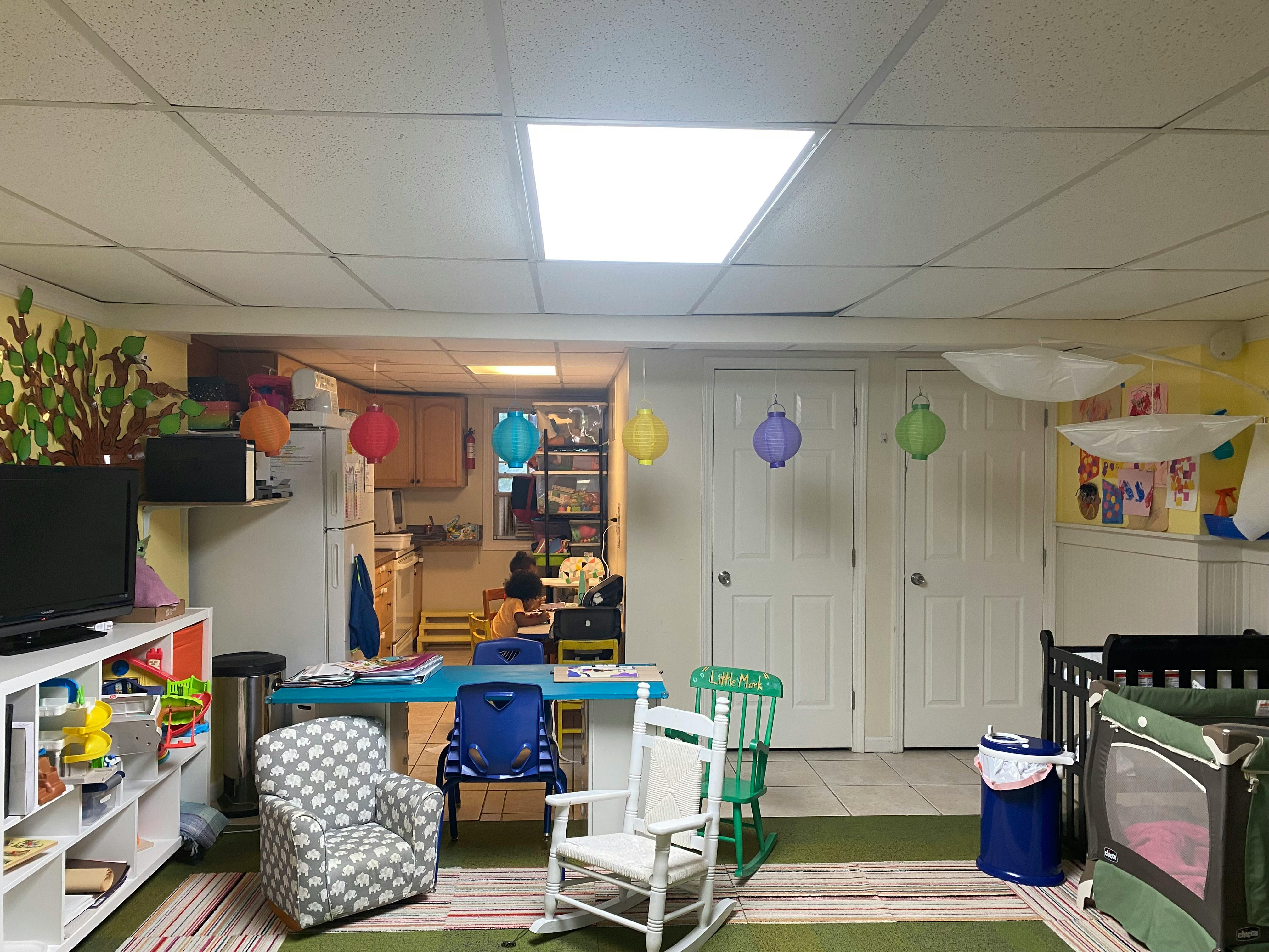 Playroom with cribs, small chairs, and a table