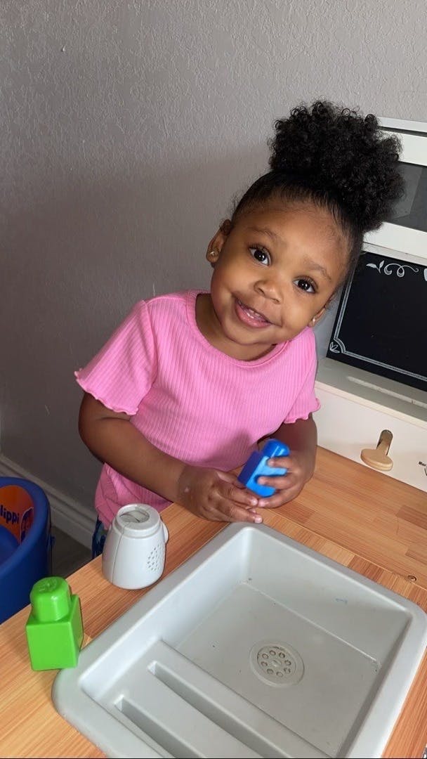 Child playing with toy kitchen set