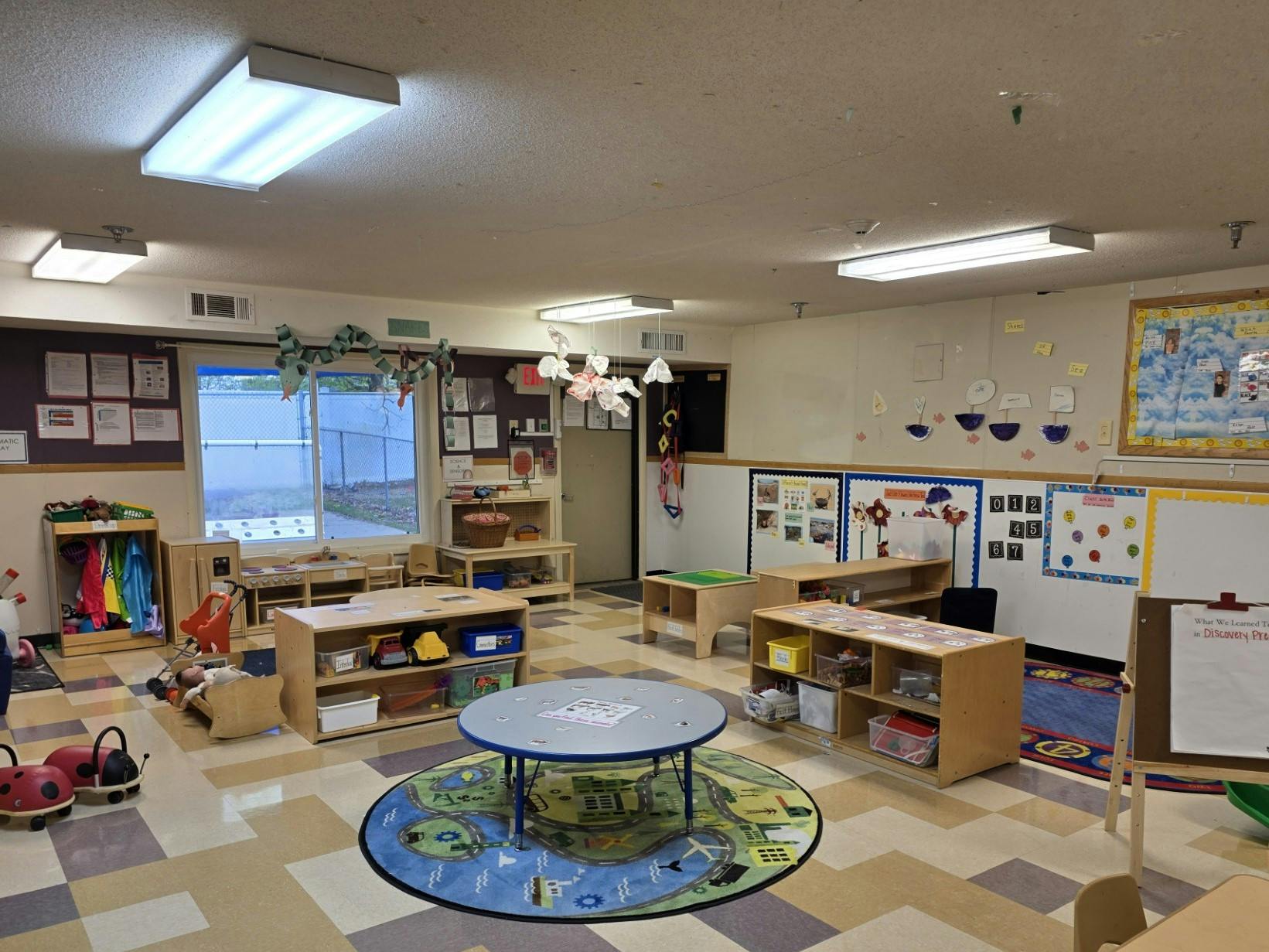 A colorful and tidy classroom with small tables, chairs, and learning materials