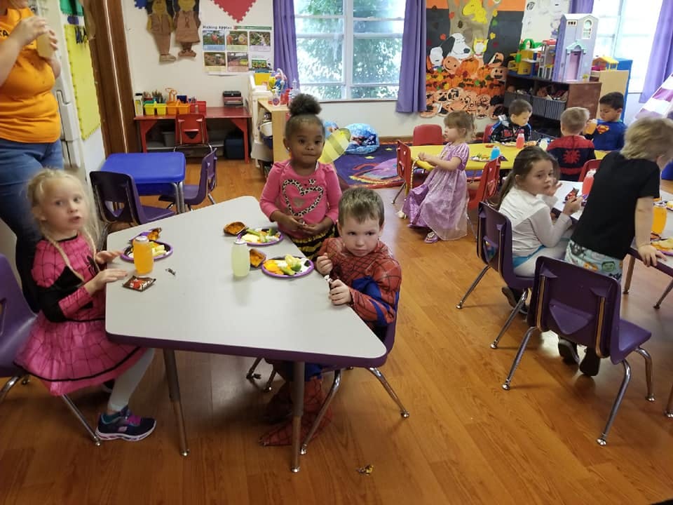 Children eating at tables in a classroom