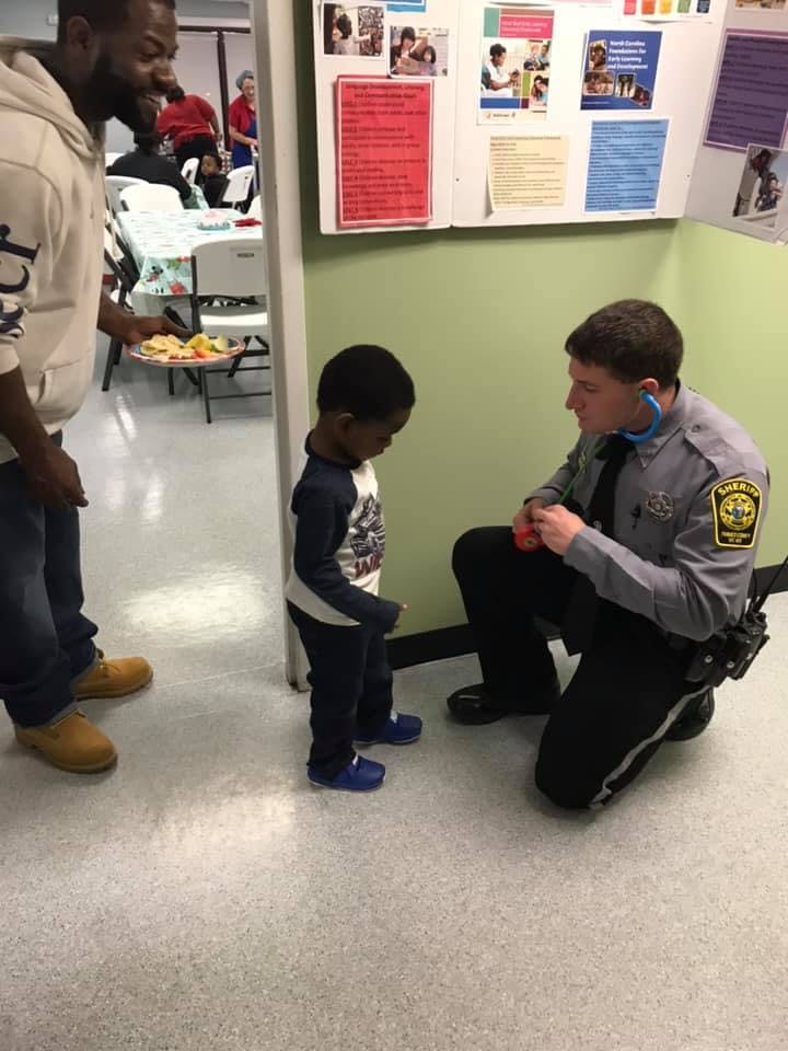 Police officer kneeling and talking to a child
