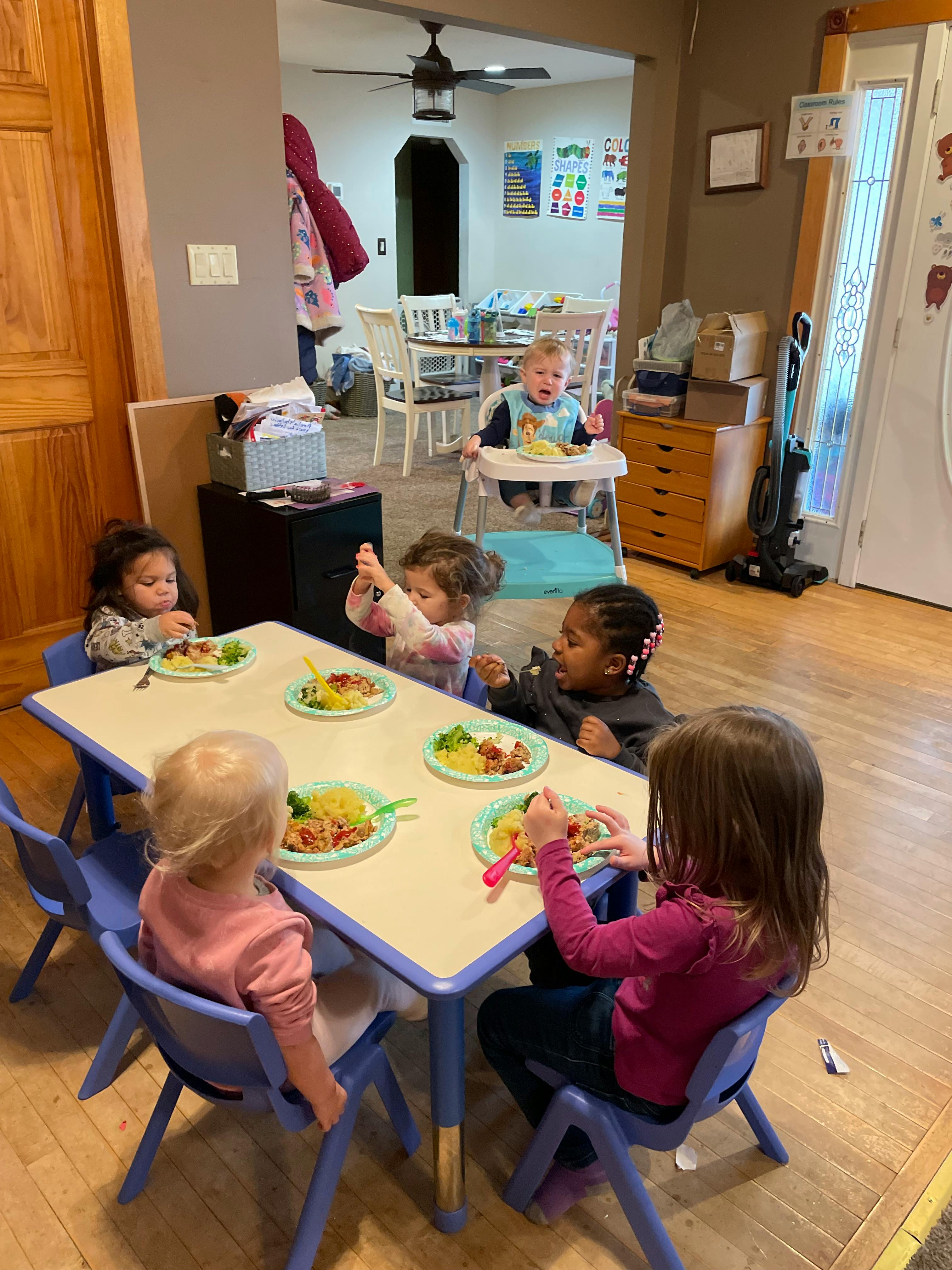 Children eating at a table in a room