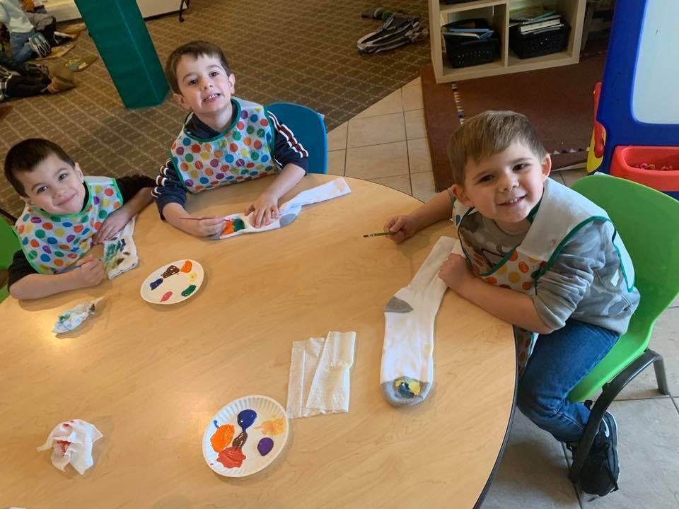 Three children painting at a table