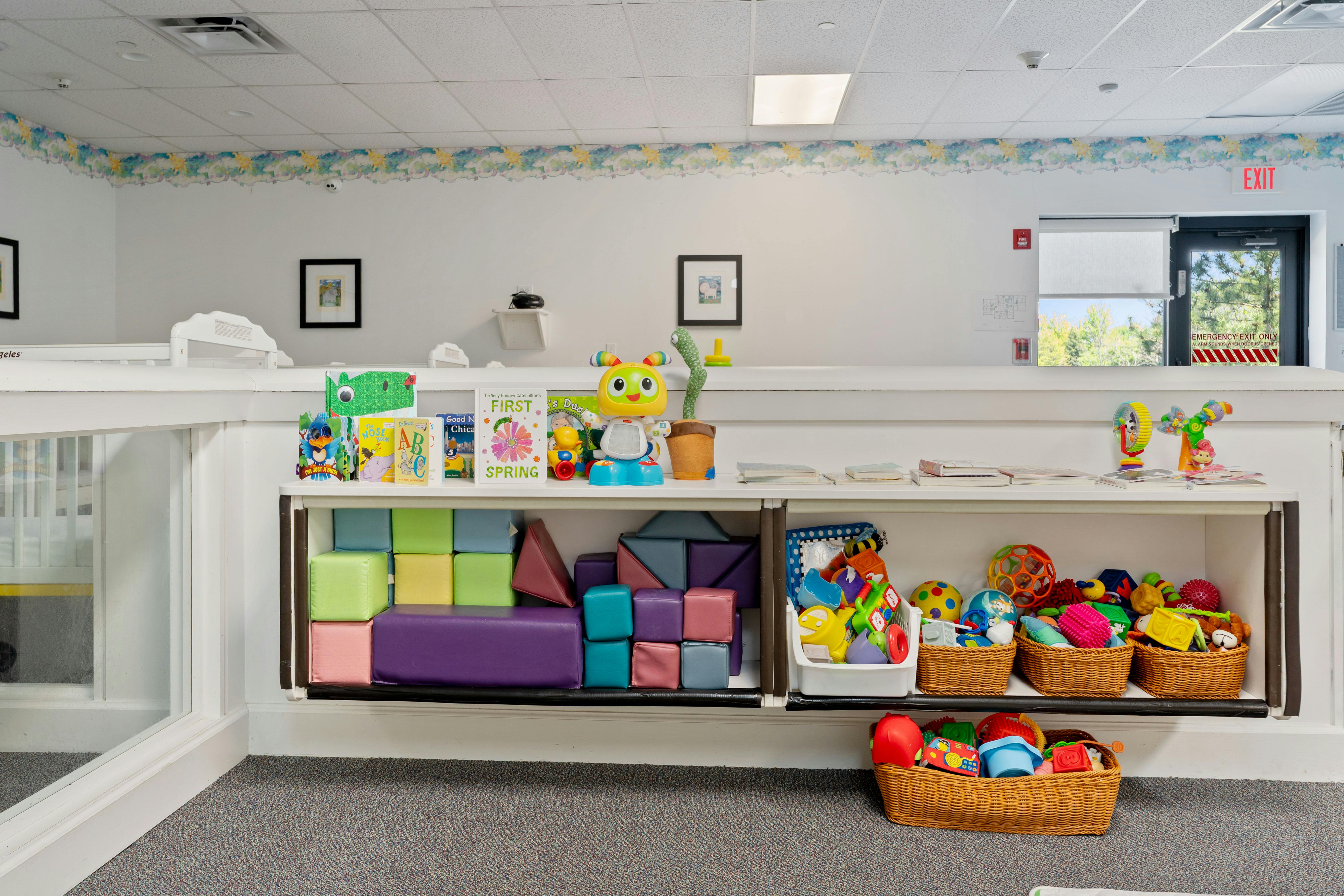 Children's classroom with books, toys, and soft play blocks on shelves