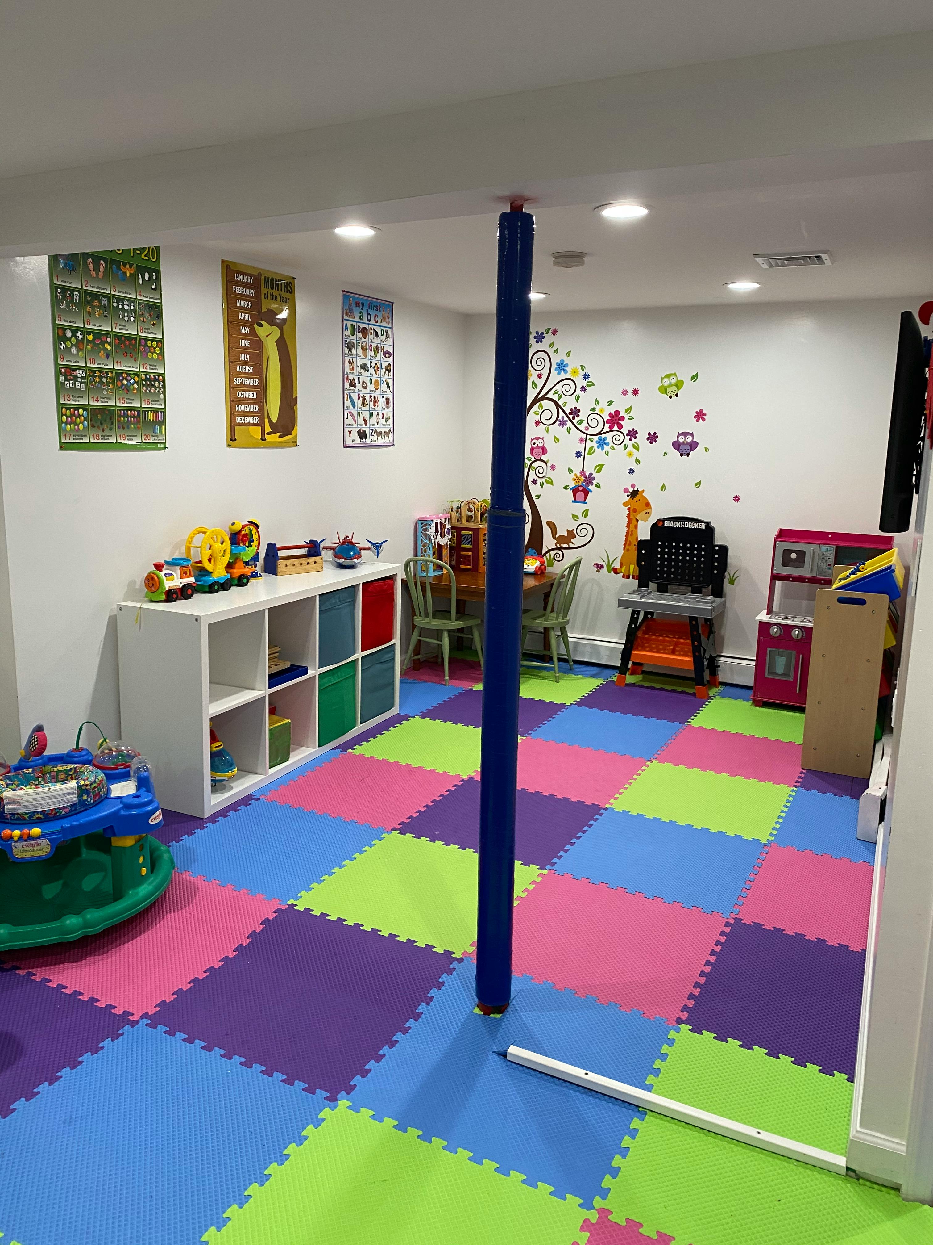 Playroom with colorful interlocking floor mats and various toys