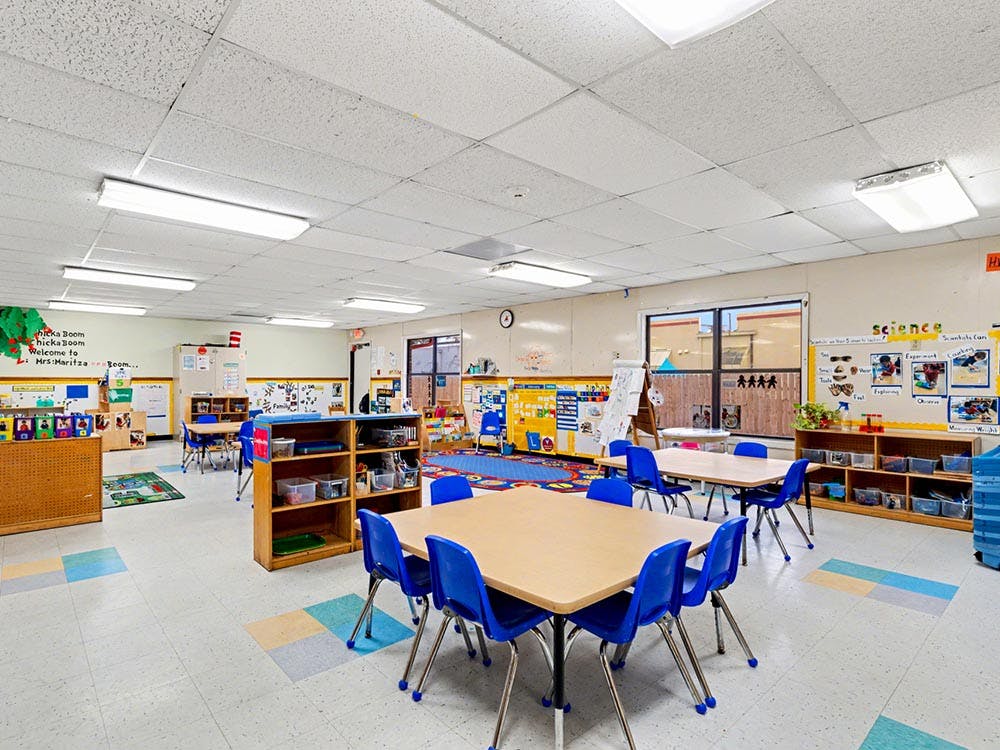 Empty classroom with small tables and chairs