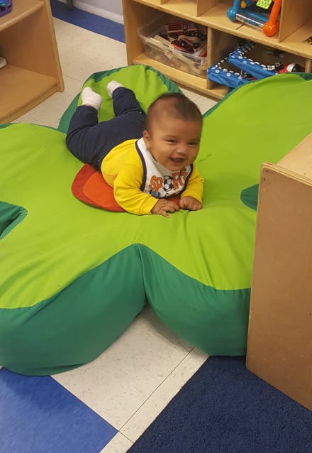 Child on stomach on a green and red mat