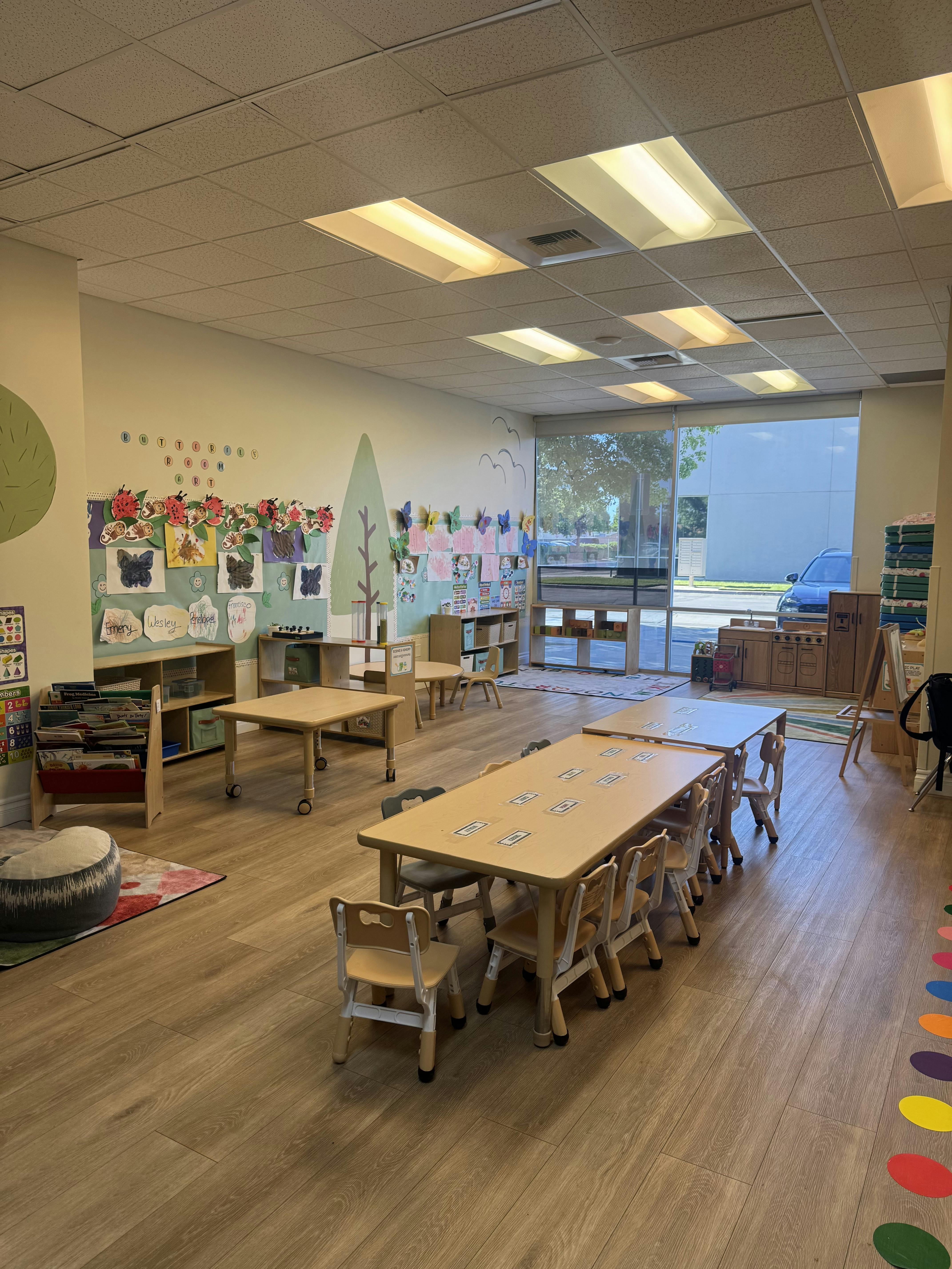 Children's classroom with tables, chairs, and artwork on the walls
