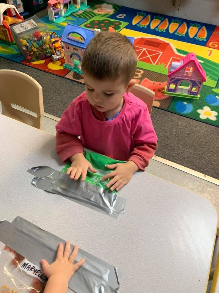 Child playing with sensory bags on a table