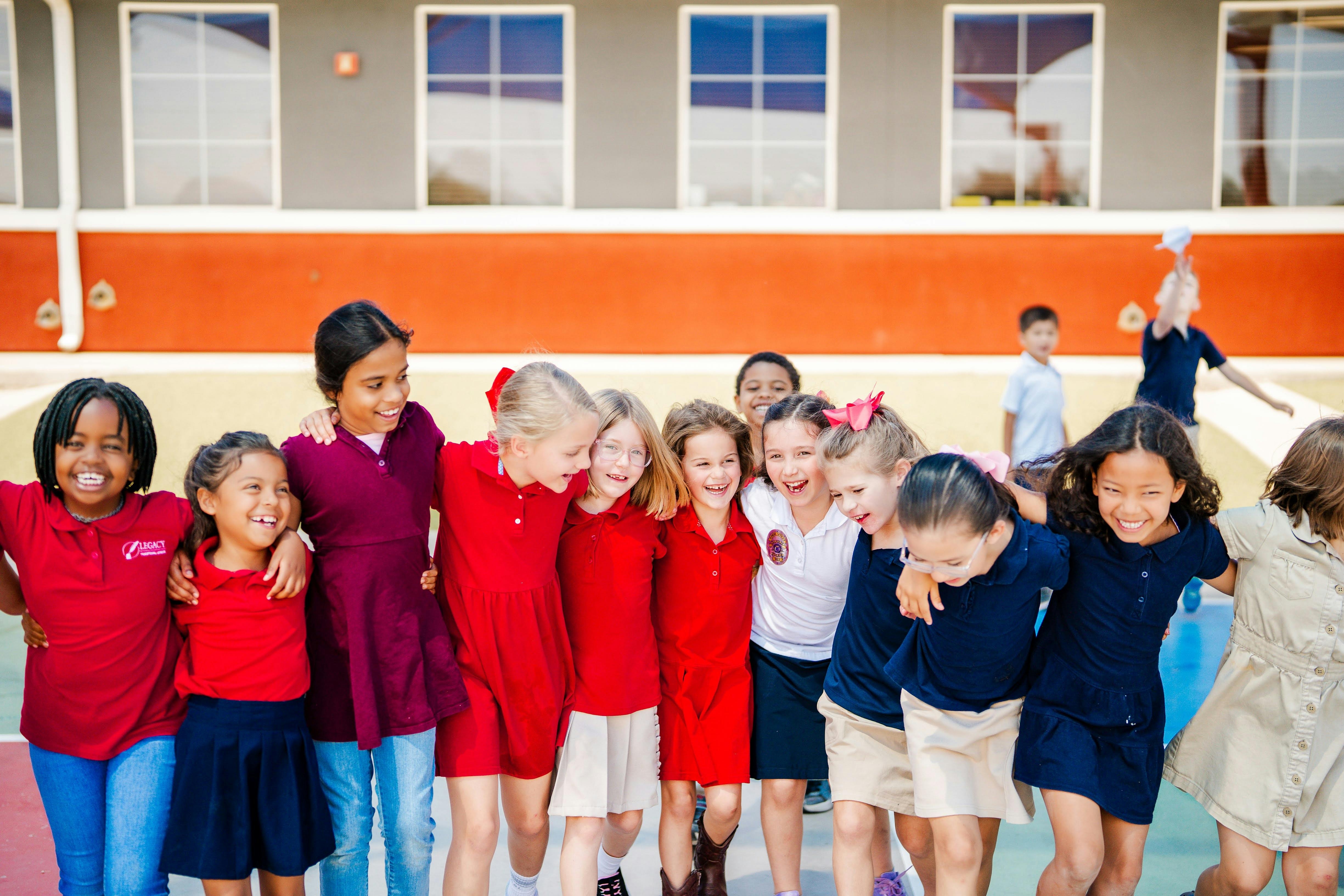 Group of children standing together, some with arms around each other