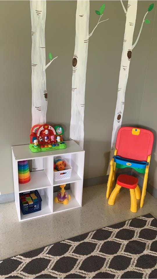 White shelving unit with toys and a child's chair
